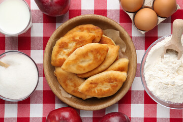 Delicious fried pyrizhky (stuffed pies) and ingredients on table, flat lay