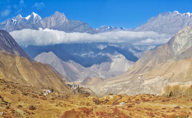 Himalayas, Nepal - The famous hiking on the roof of the world called Annapurna Circuit in the Himalaya range mountain, with little village, buddhist stupa and mountains of 8000 meters.