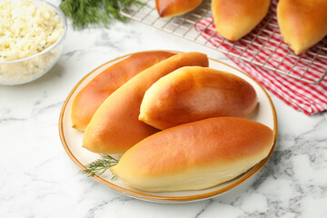 Tasty baked patties on white marble table, closeup