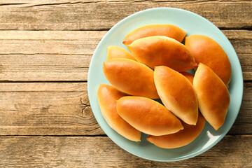 Tasty baked patties on wooden table, top view. Space for text