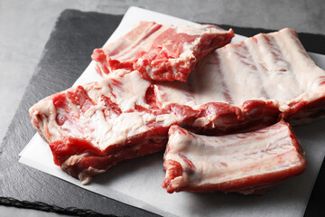 Raw pork ribs on grey table, closeup