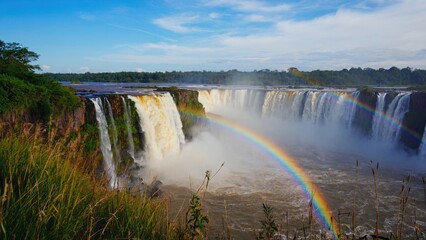 Fototapeta premium Iguazu Falls in Argentina-Brazil, showcasing a vibrant rainbow above the majestic cascade.