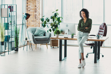 Young professional businesswoman posing confidently in a stylish and modern office environment with...
