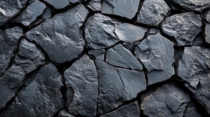 Fototapeta premium Dark volcanic rocks showcase unique, cracked textures highlighting geological formations