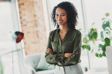 Portrait of a confident businesswoman standing in a modern office environment with natural lighting...