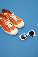 sunglasses with red sneakers on a blue background