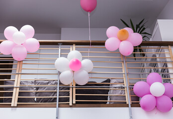 Flowers made from pink and white balloons to decorate the railing of the second floor of the house...