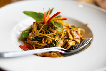 A vibrant plate of Asian-style noodles adorned with fresh herbs and colorful ingredients brings a sense of warmth and culinary delight that tempts the senses and ignites hunger.