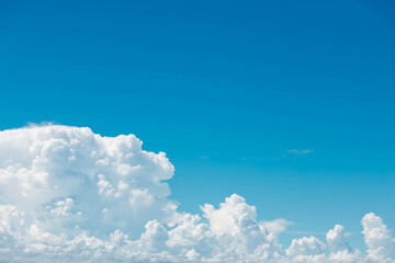 A breathtaking sky filled with soft, fluffy clouds stretching across a vibrant blue canvas creates...