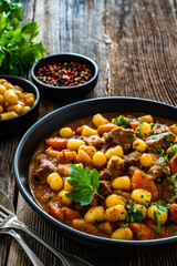 Beef vegetables goulash with gnocchi on wooden table