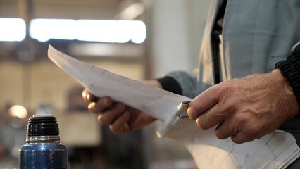 Factory worker examining plans in workshop
