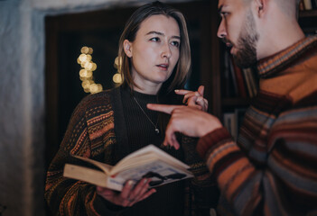 A thoughtful conversation between a man and a woman, with a cozy interior ambiance and warm lighting.