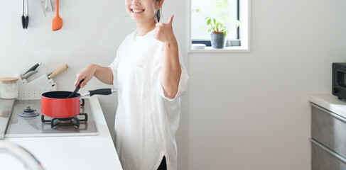 料理する女性（サムズアップ・成功） © polkadot