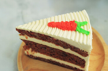 A slice of delectable carrot cake on wooden plate