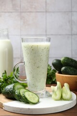 Healthy parsley drink, leaves, celery and cucumber on wooden table, closeup