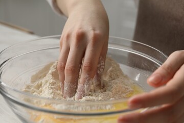 Making khinkali. Woman mixing dough at table in kitchen, closeup