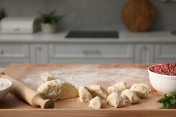 Making khinkali. Dough and stuffing on table in kitchen, space for text