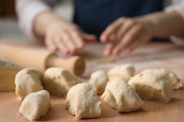 Woman making khinkali. Pieces of dough on table, closeup