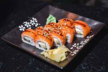 Philadelphia sushi rolls on a dark plate on a dark table