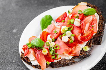 Bruschetta ham, tomato, greens dish fresh delicious gourmet food background on the table rustic food top view copy space