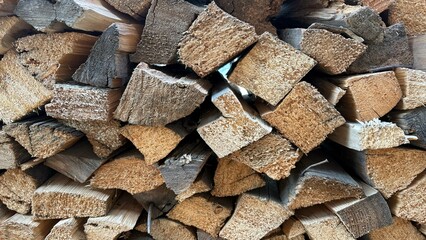 Firewood (wooden background) close-up stacked in a woodpile