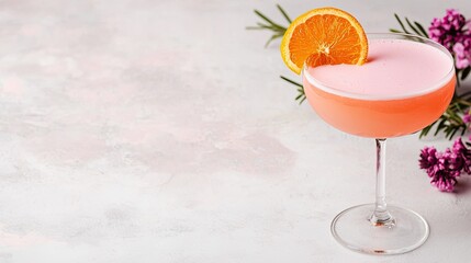 cocktail mixology minimalist concept. Refreshing pink cocktail garnished with an orange slice and flowers, set on a light textured background.
