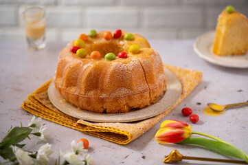 Egg liquor cake for Easter holidays. Bundt cake on a light background with tulip flowers. Easter festive food. Eierlikörkuchen in German cuisine. Food photography