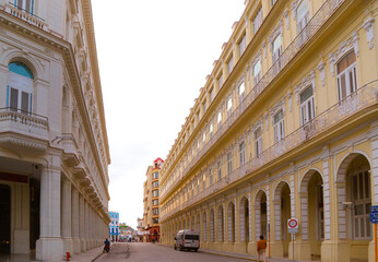 Corner view of a historic colonial building in Havana, Cuba, with deep architectural perspective, arched colonnades, and aged textures — ideal for projects about Latin American architecture,