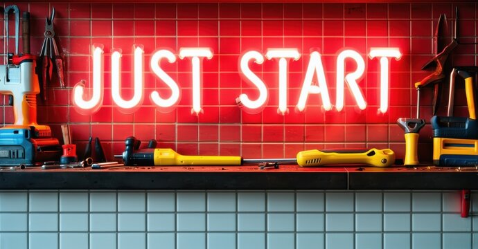 Thick neon sign just start in white and red with chunky font above tiled ledge with scattered tools and glowing hints of reflection