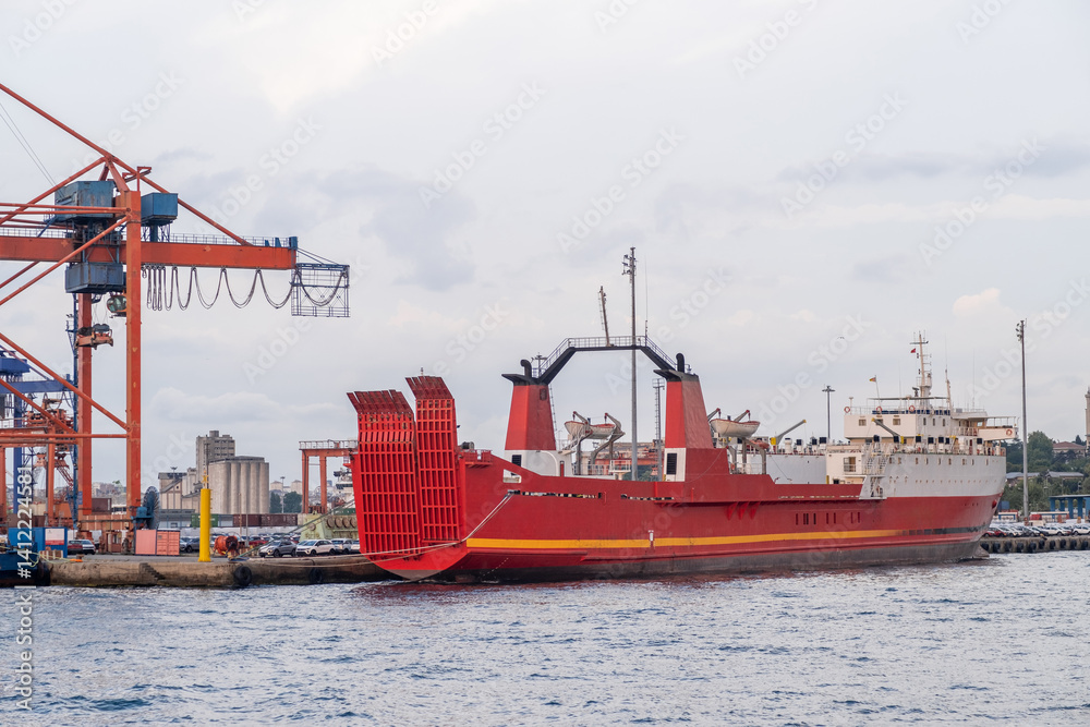 Aufkleber Cargo ship docked at Bosphorus port during evening hours with cranes in the background