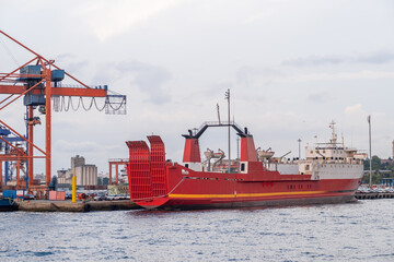 Cargo ship docked at Bosphorus port during evening hours with cranes in the background