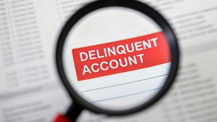 magnifying glass reveals notice about delinquent account, highlighting seriousness of debt and potential eviction