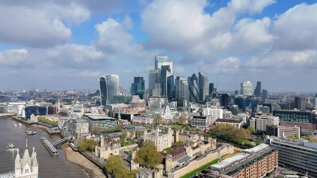Stunning drone footage captures an aerial approach to the City of London, with beautiful clouds in the background and a gleaming skyline of modern skyscrapers rising above historic architecture.