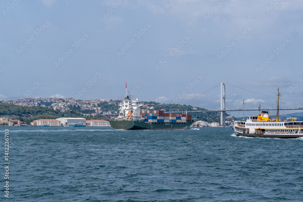 Poster container ship navigating the bosphorus with historic ferry and bridge in the background on a clear 