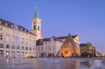 Karlsruhe Marktplatz features pyramid structure and fountain display during twilight hours