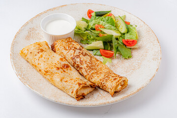 Cheese and herb-filled savory crepes with salad and dip make a delicious treat