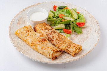 Delicate crepes filled with savory goodness accompanied by refreshing salad and dip