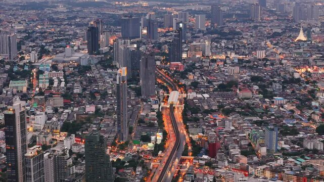 Public BTS Skytrain station and glowing Krung Thon Buri Road in Thonburi district of Bangkok at night
