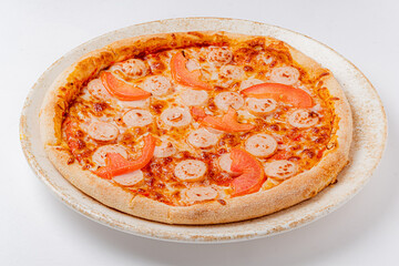 A delicious pizza with melted cheese and slices of tomato awaits hungry diners, crafted with care
