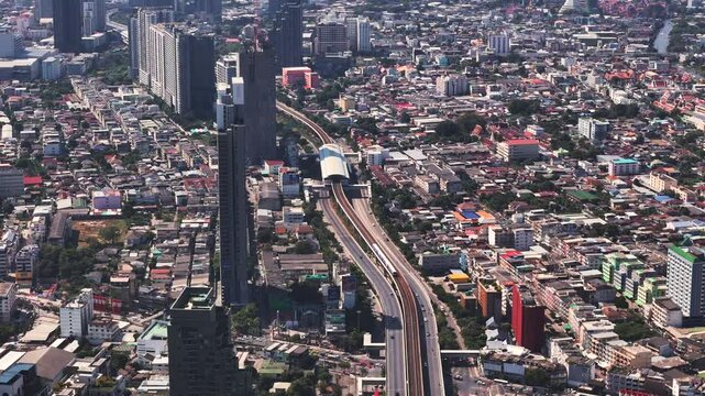 Overpass BTS skytrain railway of Bangkok stretches among tall buildings in Thonburi district