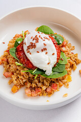 Brunch features a generous serving of warm oats topped with a poached egg, spinach, and salsa