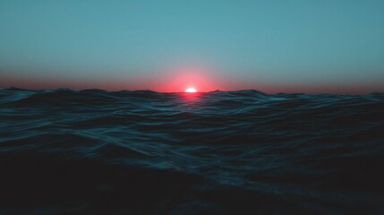 Fototapeta premium Sunset over the Ocean Calm waves reflect vibrant sky at the horizon