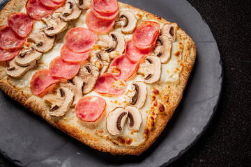 Tasty pizza with a crispy crust, topped with pepperoni and mushrooms, ready to enjoy!