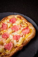 Delicious ham and pineapple pizza on a rustic plate, inviting and beautifully presented