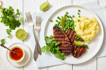 grilled beef cutlets with potato mash, green peas