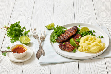 grilled beef cutlets with potato mash, green peas