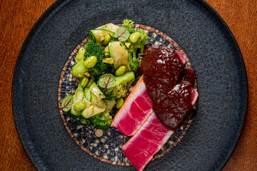 Grilled meat served with a vibrant, textured vegetable salad