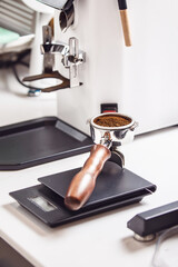 Close-up of Barista with Featuring Portafilter Filled With Fresh Coffee Grounds on Scale for Precision Measurement