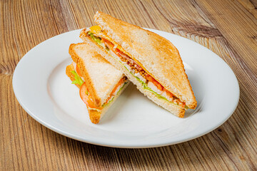 A hearty sandwich filled with fresh vegetables and meats sits invitingly on a plate