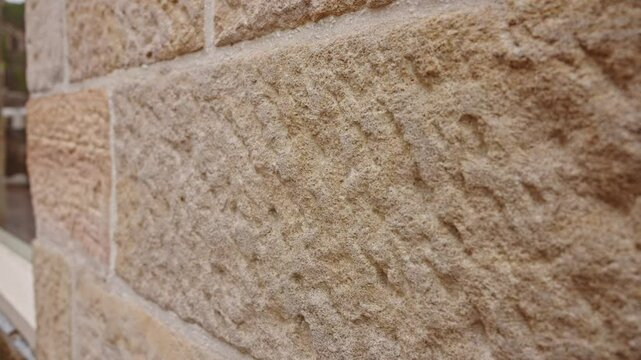 An extreme close-up of a weathered sandstone brick from a historic building, revealing its intricate texture and geological patterns.